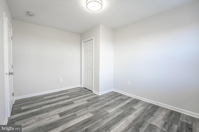 unfurnished bedroom featuring dark hardwood / wood-style flooring and a closet