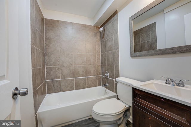 full bathroom with hardwood / wood-style floors, vanity, toilet, and tiled shower / bath