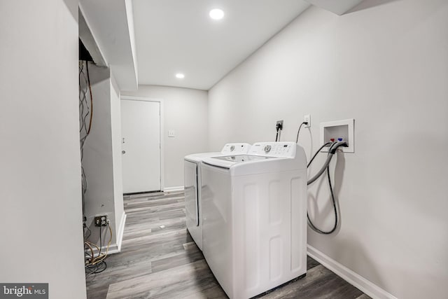 clothes washing area with washing machine and dryer and light hardwood / wood-style flooring