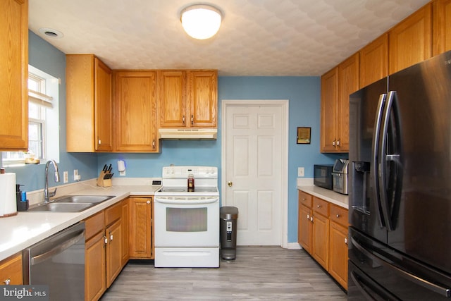 kitchen featuring dishwasher, sink, black fridge, light hardwood / wood-style flooring, and white electric stove