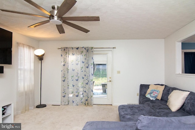 carpeted living room with ceiling fan and a textured ceiling