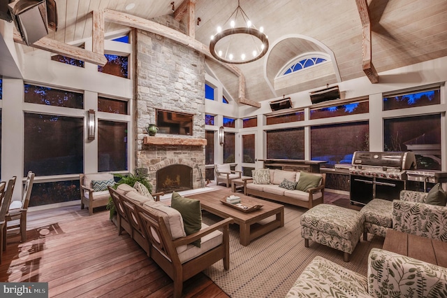 interior space with beam ceiling, hardwood / wood-style flooring, an inviting chandelier, high vaulted ceiling, and a fireplace