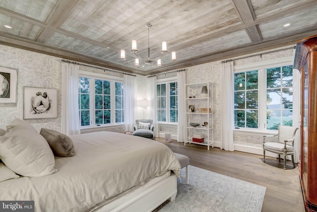 bedroom featuring hardwood / wood-style flooring, crown molding, a notable chandelier, and coffered ceiling