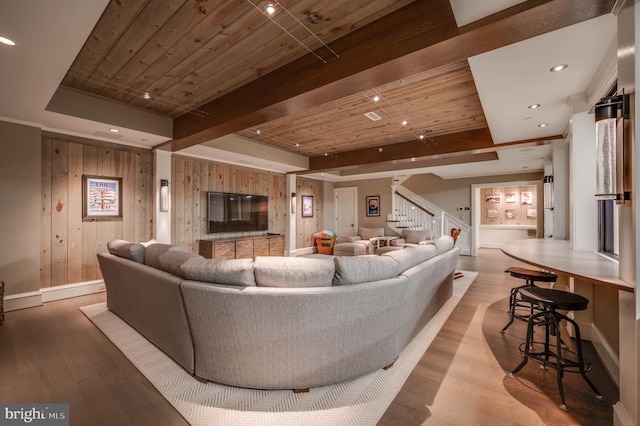 living room featuring beamed ceiling, light hardwood / wood-style floors, wooden ceiling, and wood walls