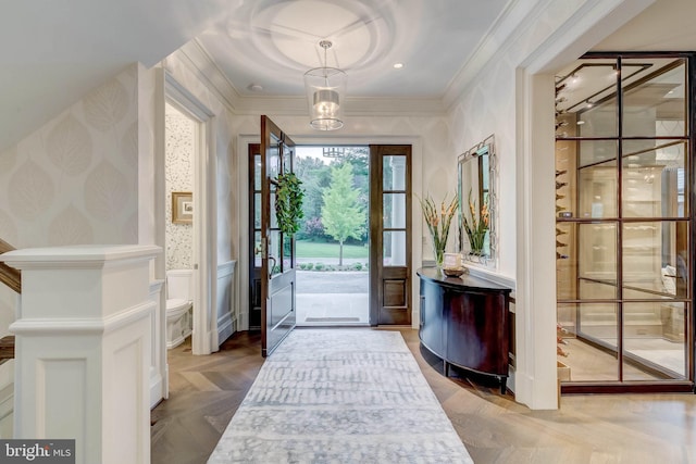 entrance foyer featuring crown molding and parquet flooring