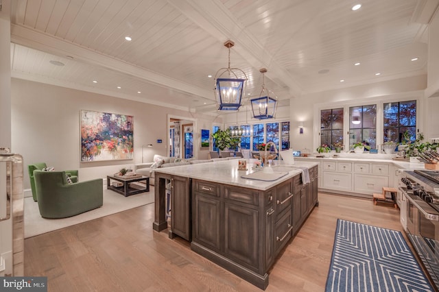 kitchen featuring dark brown cabinetry, light hardwood / wood-style flooring, a notable chandelier, decorative light fixtures, and white cabinets