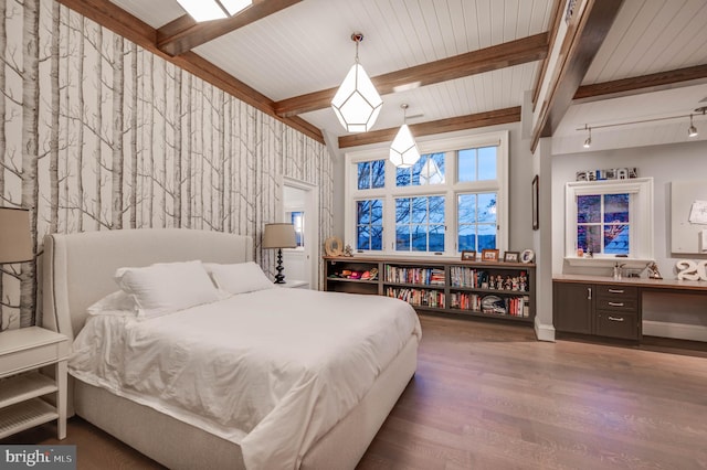 bedroom with beam ceiling, dark hardwood / wood-style flooring, and rail lighting