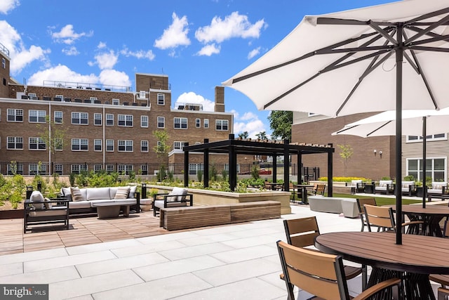 view of community featuring a pergola, an outdoor hangout area, and a patio area