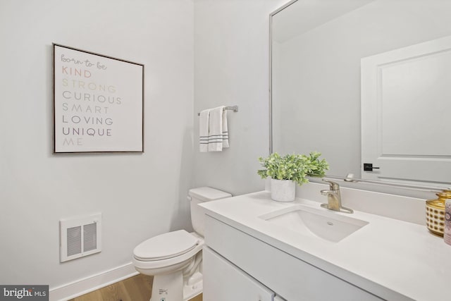 bathroom featuring hardwood / wood-style floors, vanity, and toilet