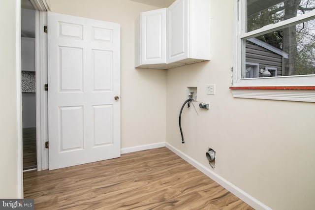 laundry room with washer hookup, cabinets, and light hardwood / wood-style flooring