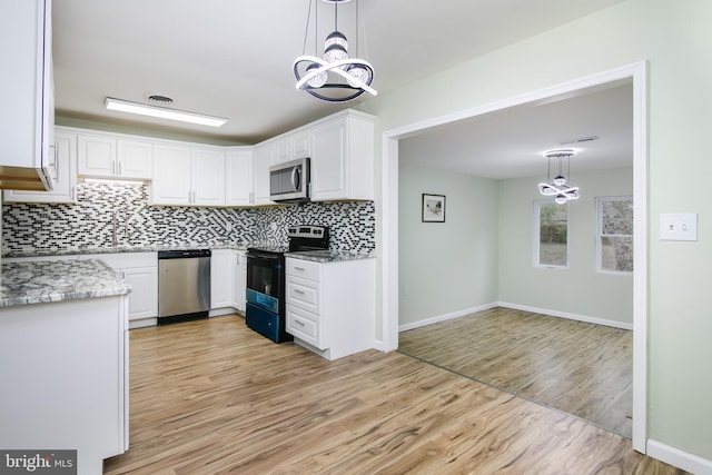 kitchen with white cabinets, appliances with stainless steel finishes, and decorative light fixtures