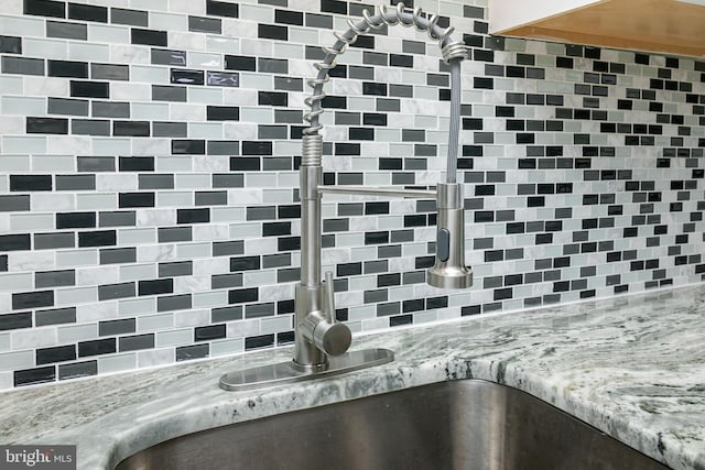 details featuring light stone countertops and sink