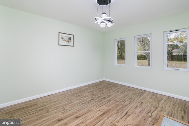 unfurnished room featuring light hardwood / wood-style floors and a notable chandelier