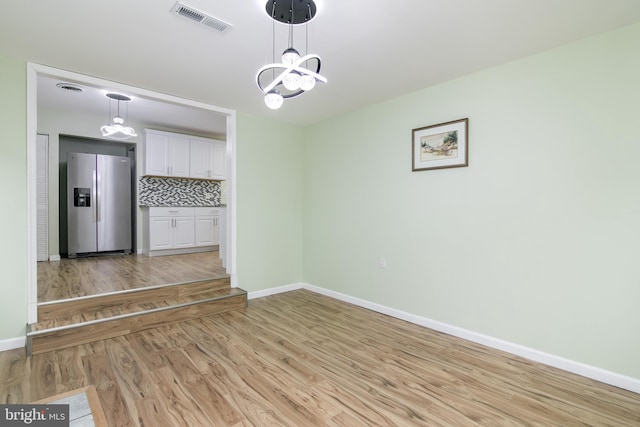 interior space featuring light wood-type flooring and a notable chandelier