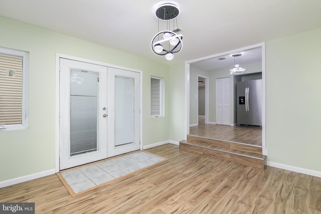 entrance foyer featuring french doors and light hardwood / wood-style flooring