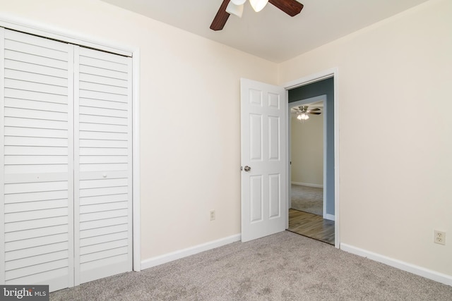 unfurnished bedroom featuring ceiling fan, light colored carpet, and a closet