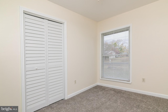 unfurnished bedroom featuring light carpet and a closet