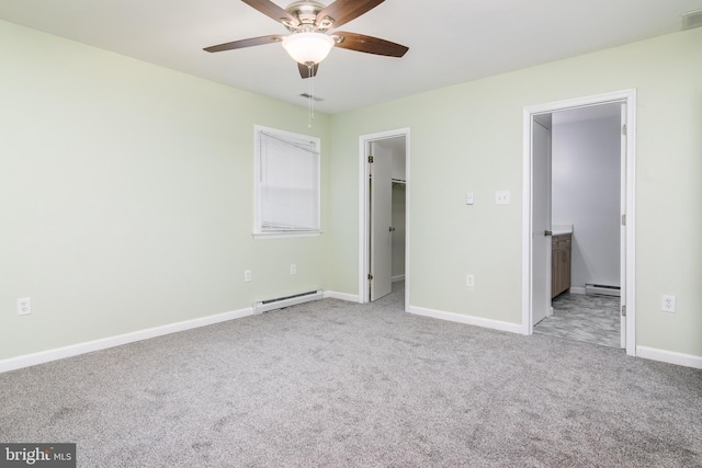 unfurnished bedroom with light carpet, a walk in closet, ensuite bath, and a baseboard heating unit