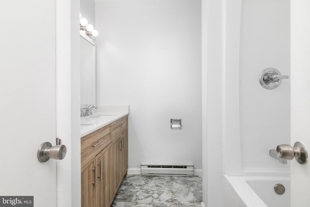 bathroom featuring baseboard heating and vanity