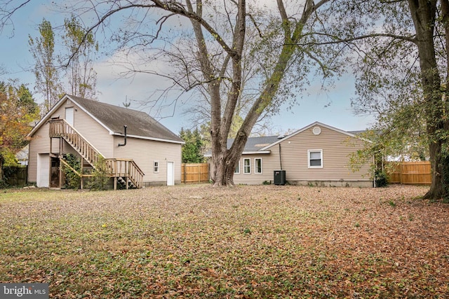 back of house with a garage and central air condition unit