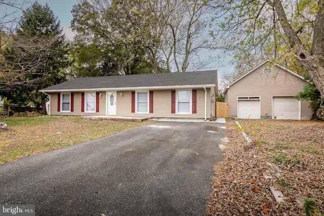 ranch-style home featuring an outbuilding, a garage, and a front lawn