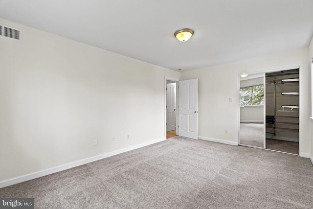 unfurnished bedroom featuring a closet and light colored carpet