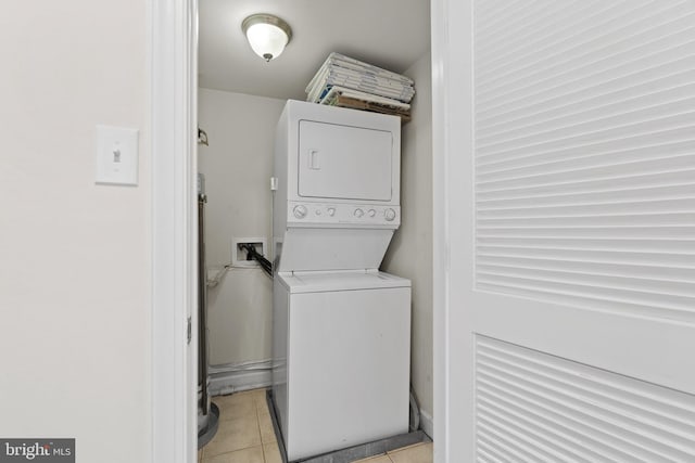 washroom with light tile patterned flooring and stacked washer and clothes dryer