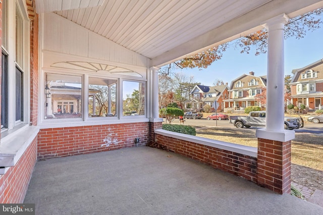 exterior space with wood ceiling, ornate columns, and lofted ceiling