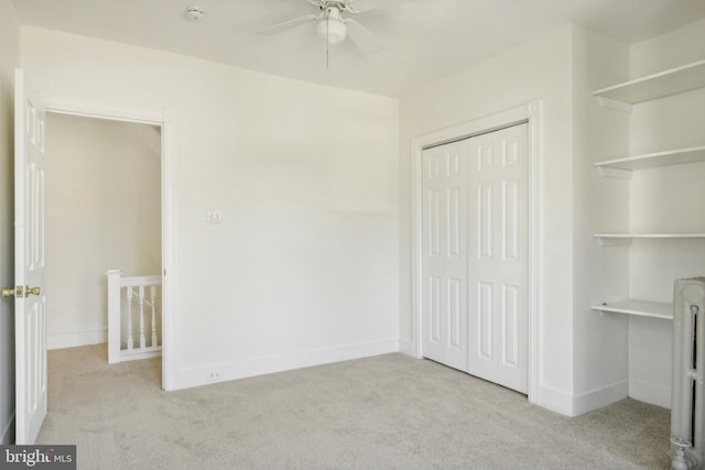 unfurnished bedroom with a closet, light carpet, and ceiling fan