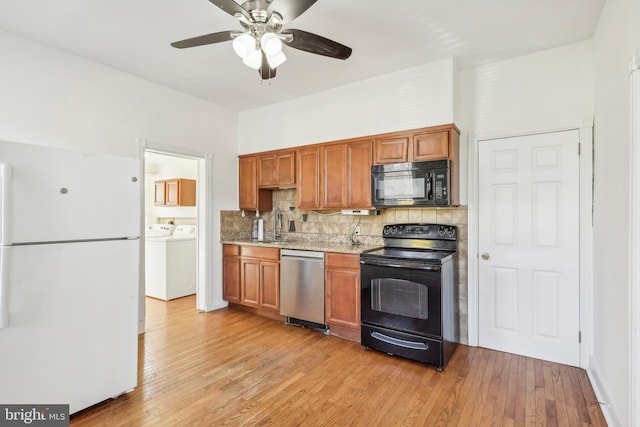 kitchen featuring black appliances, ceiling fan, washing machine and clothes dryer, light wood-type flooring, and decorative backsplash