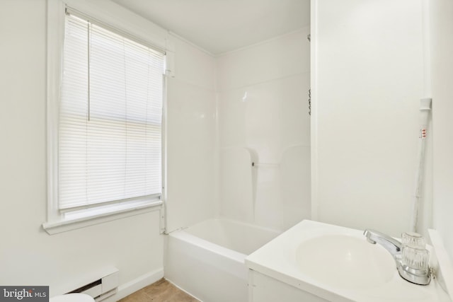 bathroom featuring shower / washtub combination, sink, and a baseboard heating unit