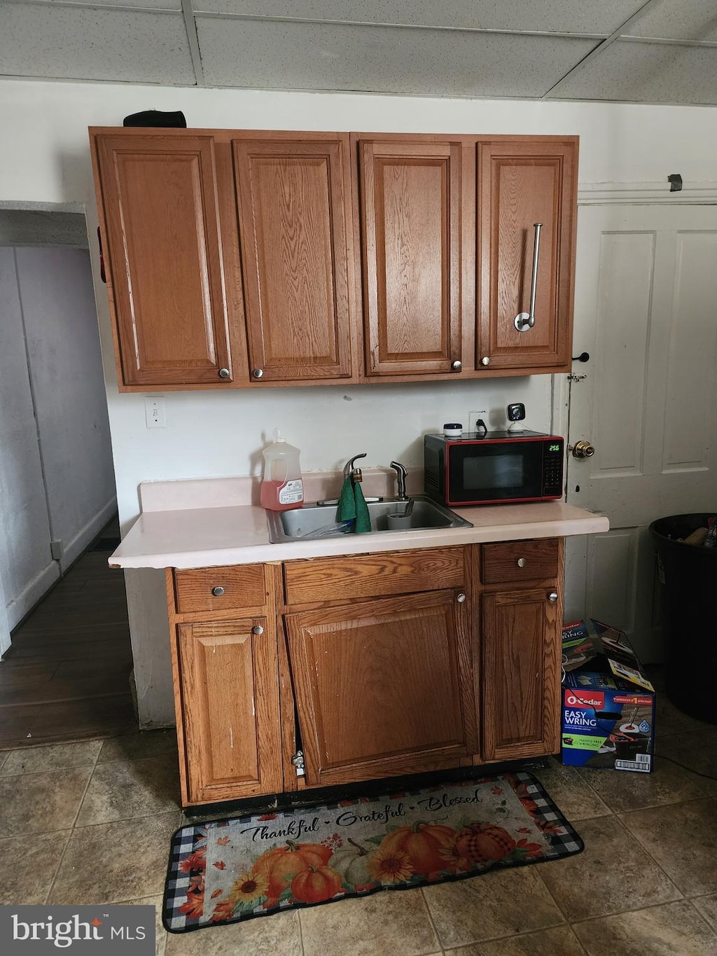 kitchen with a paneled ceiling and sink