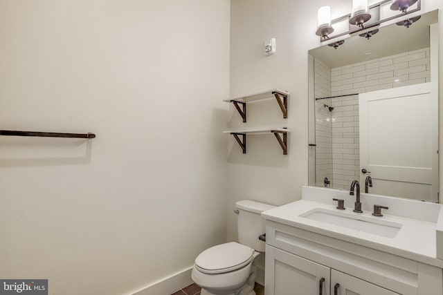 bathroom featuring a tile shower, vanity, and toilet