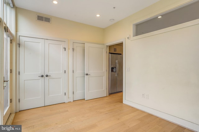 1510 N Capitol St NW Unit 102, Washington, DC 20002 - unfurnished bedroom featuring stainless steel refrigerator with ice dispenser, light wood finished floors, multiple closets, and recessed lighting