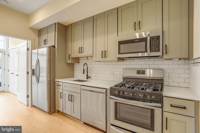 1510 N Capitol St NW Unit 102, Washington, DC 20002 - kitchen featuring stainless steel appliances, a sink, light countertops, light wood-type flooring, and tasteful backsplash