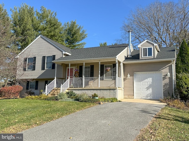 split level home featuring a porch, a garage, and a front yard