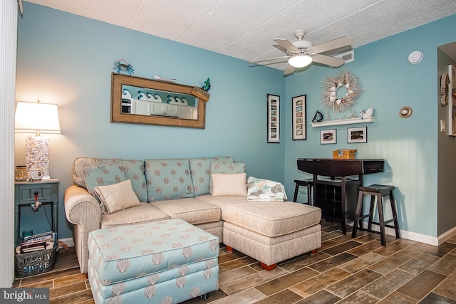 living room featuring dark hardwood / wood-style floors, ceiling fan, and a textured ceiling