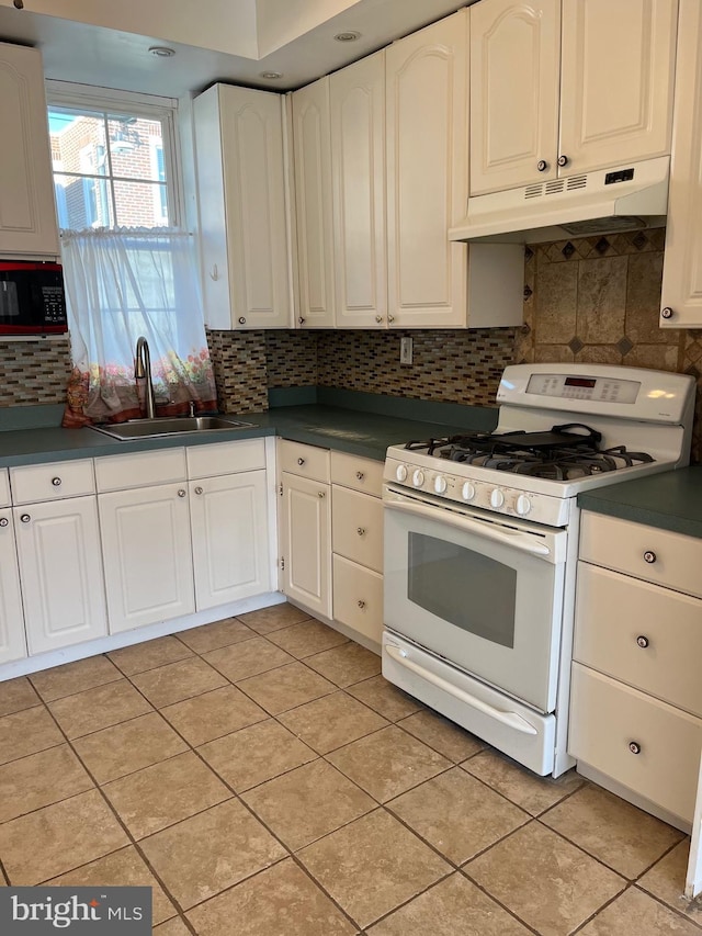 3358 Livingston St, Philadelphia, PA 19134 - kitchen with white gas range, under cabinet range hood, a sink, dark countertops, and white cabinetry