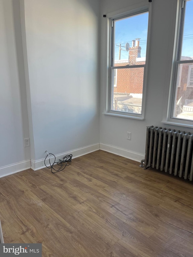 unfurnished room with radiator heating unit and dark wood-type flooring