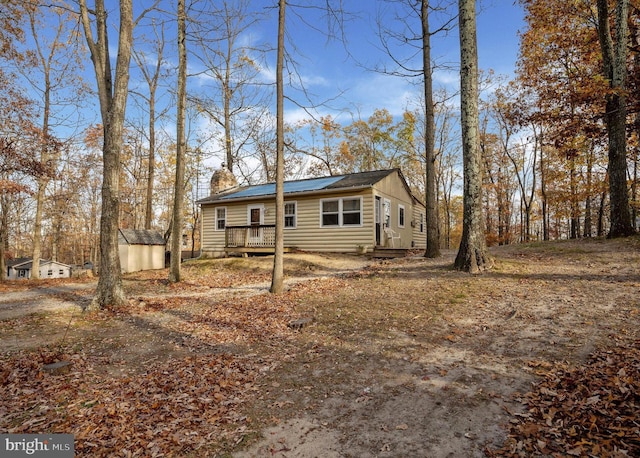 view of front of property featuring a storage shed and a deck