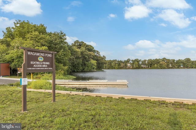 view of dock with a water view and a lawn