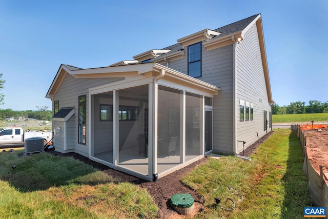 back of property featuring a yard, cooling unit, and a sunroom