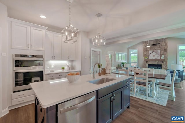 kitchen with a wealth of natural light, white cabinetry, sink, and appliances with stainless steel finishes