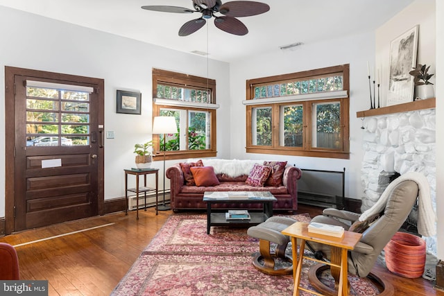 living area featuring hardwood / wood-style floors, ceiling fan, a healthy amount of sunlight, and a baseboard radiator