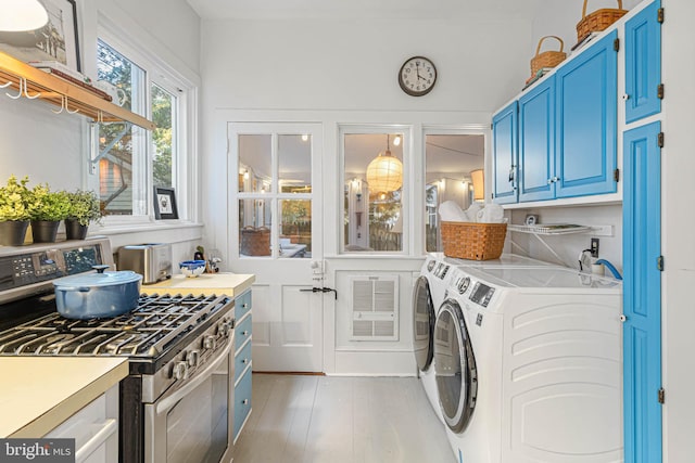 washroom with washer and dryer and light hardwood / wood-style floors