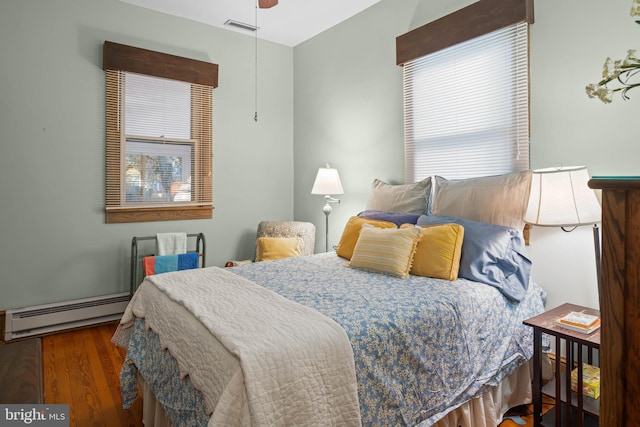 bedroom featuring baseboard heating, ceiling fan, and hardwood / wood-style flooring