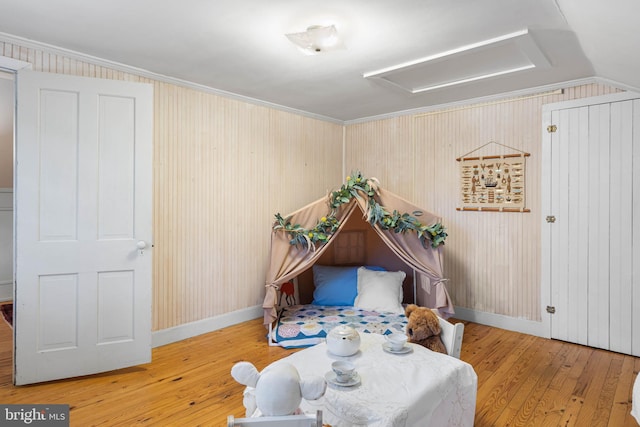 living area featuring wood-type flooring, lofted ceiling, and ornamental molding