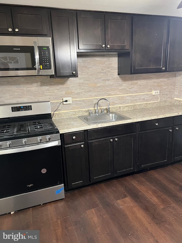 kitchen with dark hardwood / wood-style floors, sink, appliances with stainless steel finishes, and tasteful backsplash