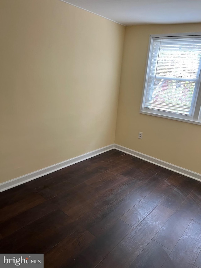 empty room with dark hardwood / wood-style flooring