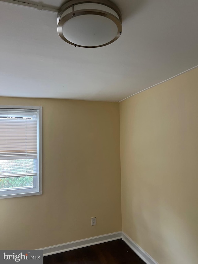 spare room featuring dark wood-type flooring